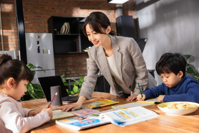 青年女人辅导小学生在家学习