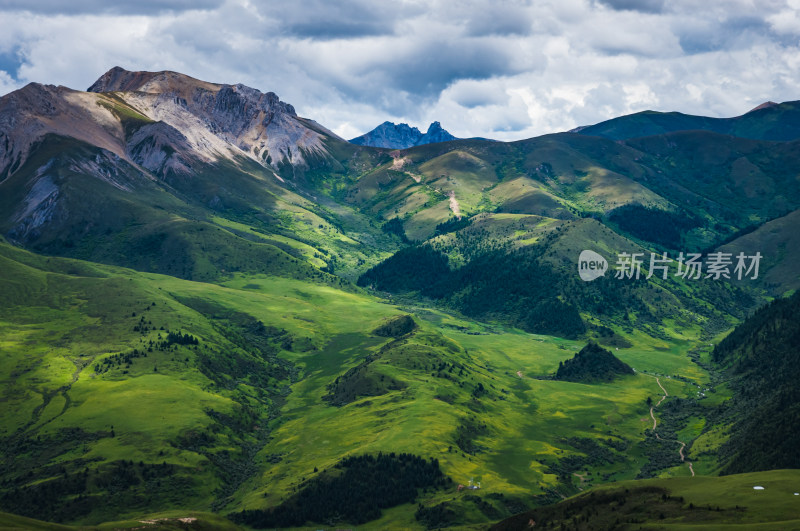 蓝天白云下广袤草原与连绵山峦自然风景