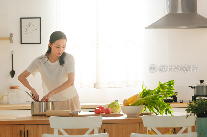 青年女人在厨房里做饭