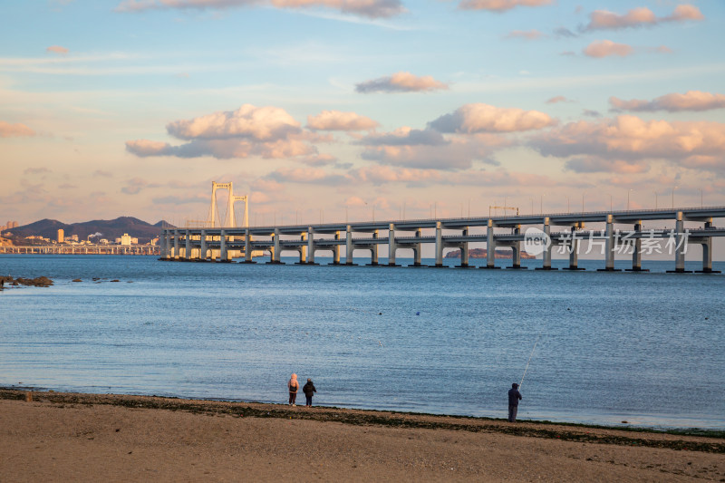 黄昏日落时的大连黑石礁公园海滩和跨海大桥