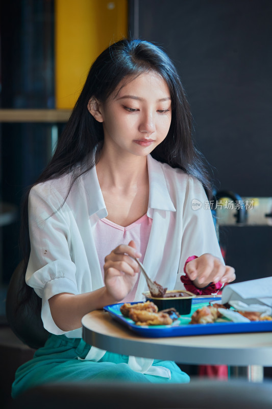 在商场快餐厅大吃特吃的中国可爱少女人像