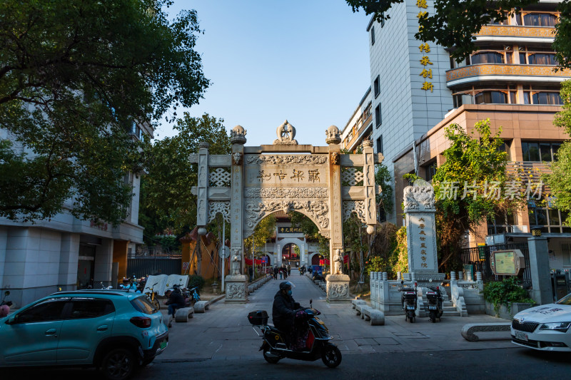 石牌坊建筑街道上的车辆和行人