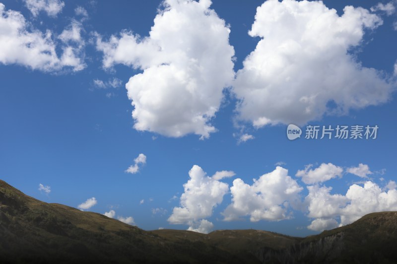 中国四川甘孜蓝天白云下的青山