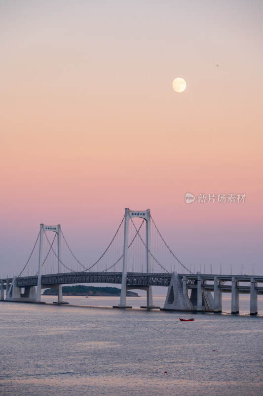 夕阳下大连星海湾大桥上空升起的月亮