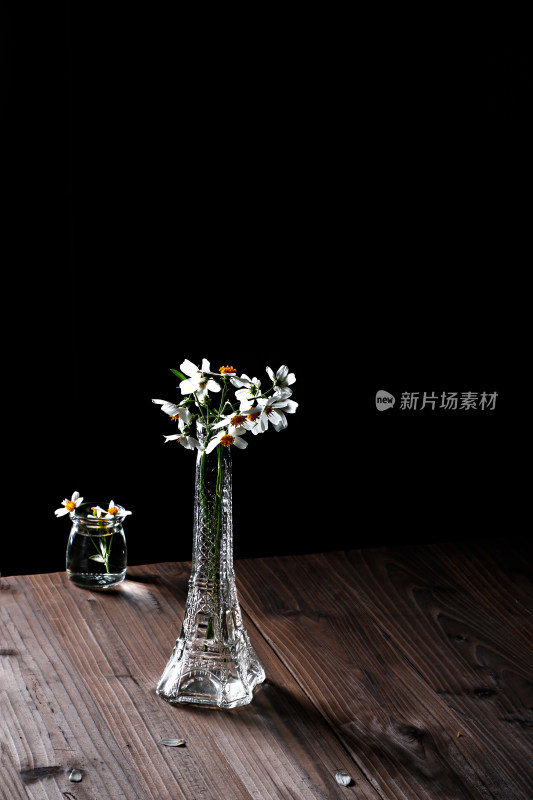 阳光下玻璃瓶里的插花白色雏菊和光影