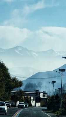 道路上车辆行驶，远处群山云雾缭绕