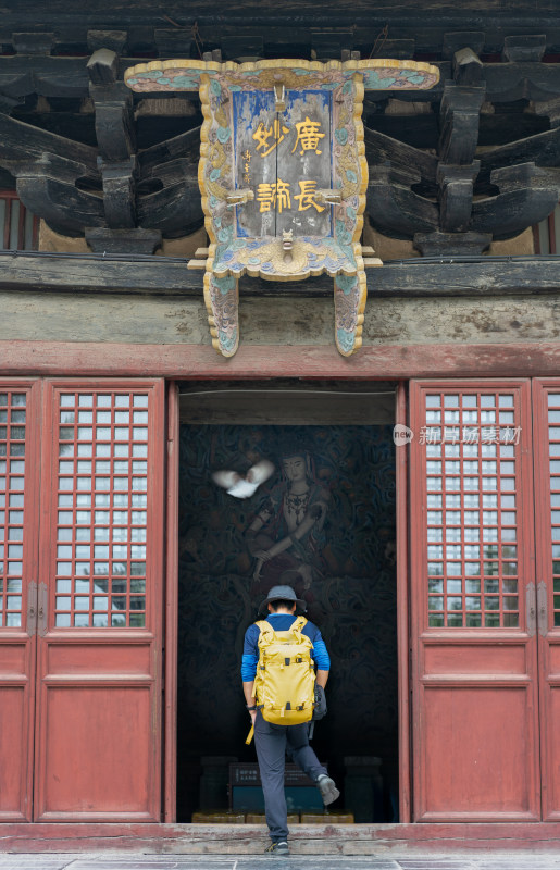 背着背包的人站在正定隆兴寺古建筑门前