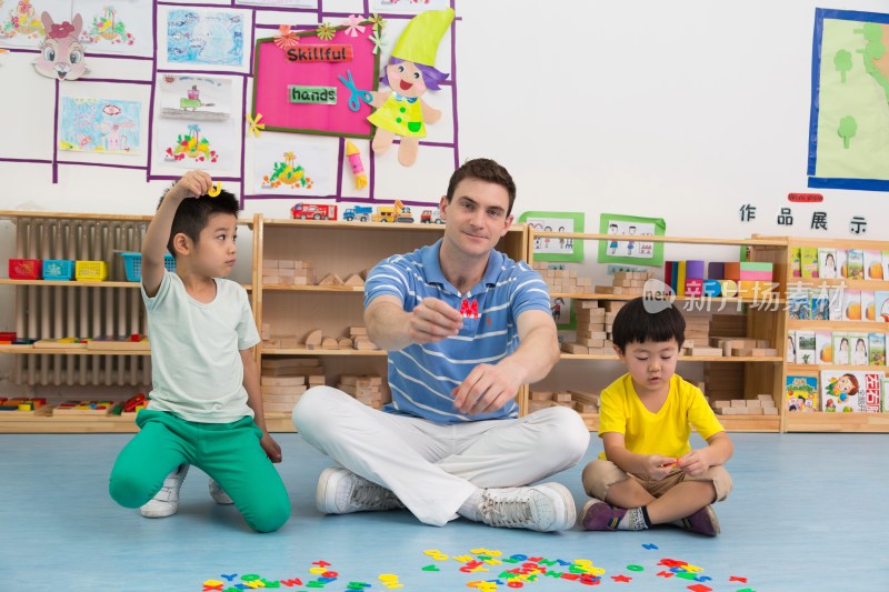 幼儿园外教男老师和儿童一起玩字母游戏