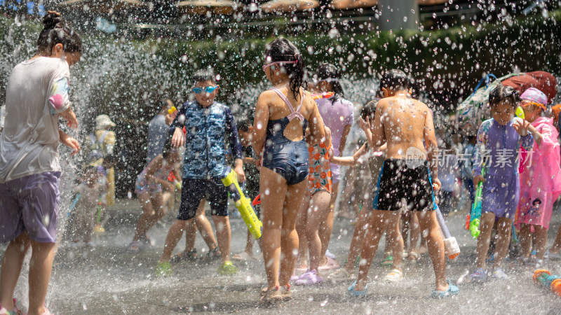 暑假小朋友在地面喷泉玩水清凉特写