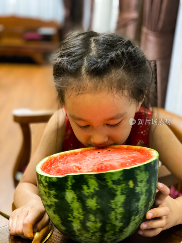 小女孩双手捧食大西瓜