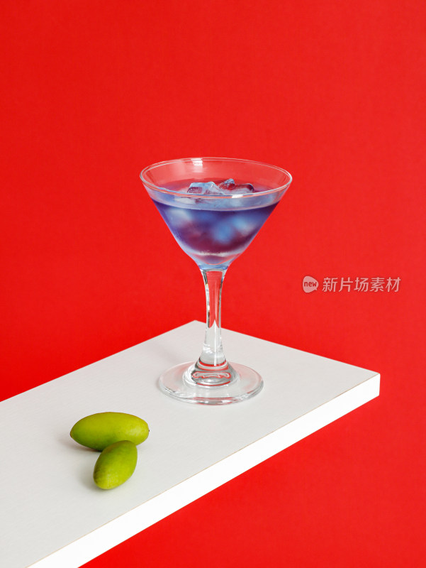 红色背景上，一杯蓝色的鸡尾酒饮品
