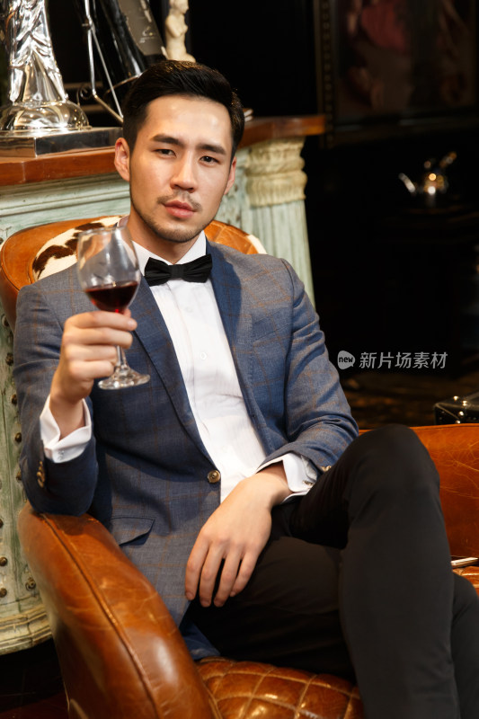 青年男人拿着红葡萄酒杯