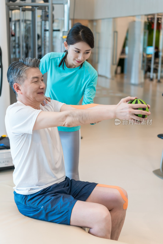 老年男子在私教的指导下健身