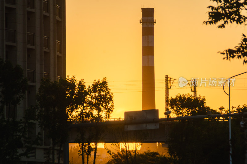 夕阳下带烟囱的城市建筑景象