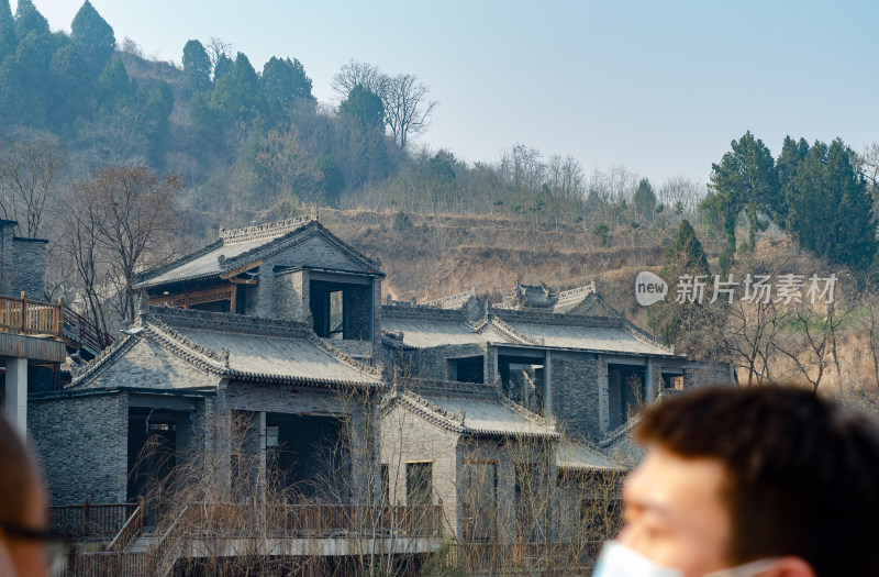 游客经过渭南桃花源景区荒废的古建筑