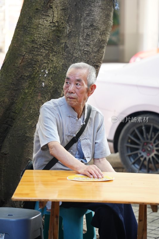 树下休憩的老年男子