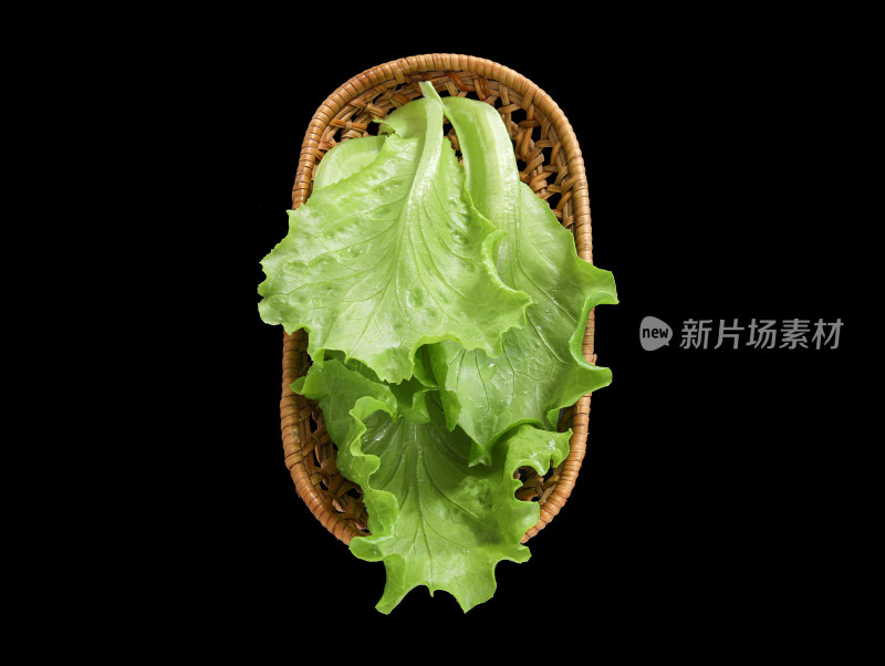 黑色背景上一篮子的新鲜绿色蔬菜生菜