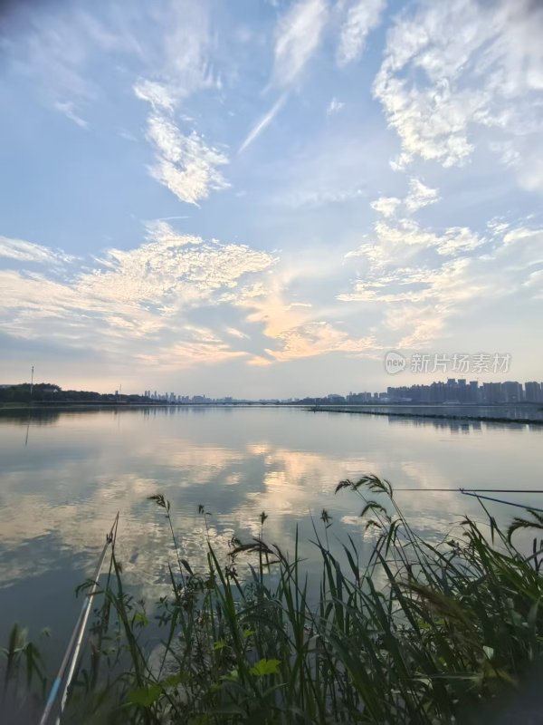 湖边清晨天空与水面相映成趣的美景