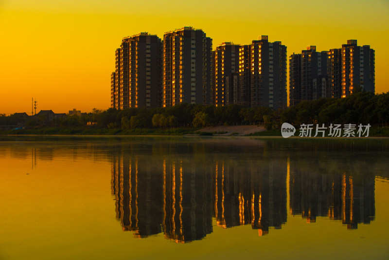 夕阳下湖边高楼倒影