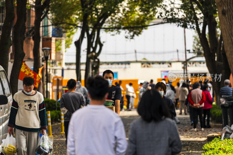 居民戴着口罩在小区内活动的场景