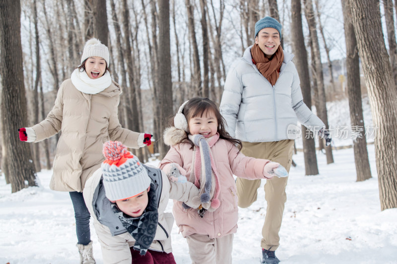 欢乐家庭在雪地里奔跑