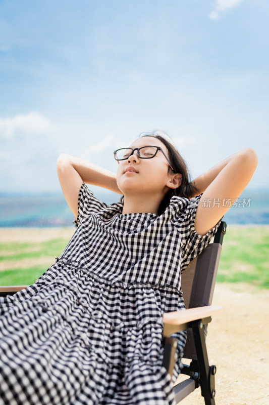 女孩户外躺椅上放松休憩