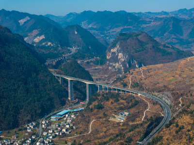 山间城镇全景，高架公路贯穿其中