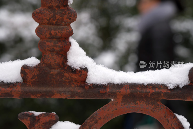 围墙的金属栅栏上堆积着洁净的白雪