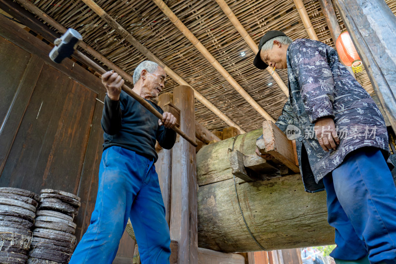 传统油坊榨油老人抡大锤劳作