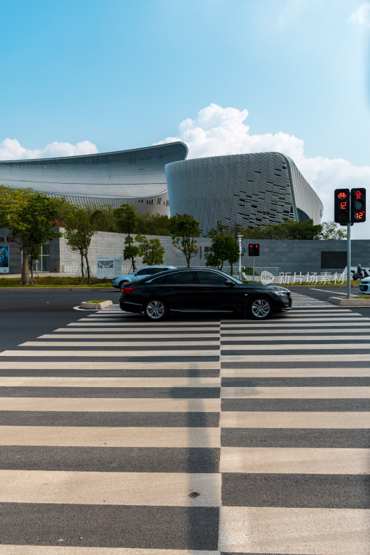 现代建筑前有车辆的斑马线街景