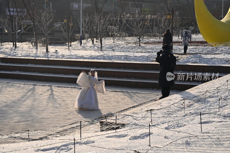 雪地里穿着古装的女子正在拍照