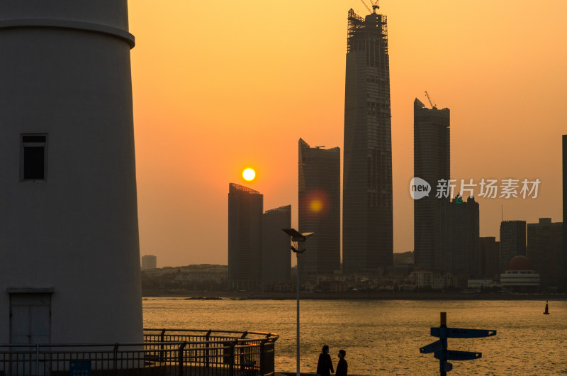 青岛奥帆中心灯塔，对岸落日下的海天中心