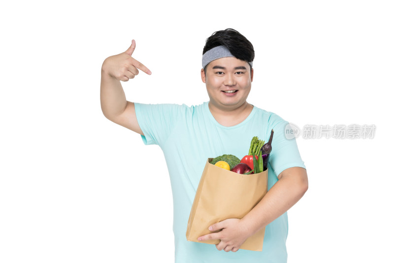 肥胖的年轻男子拿着各种蔬菜