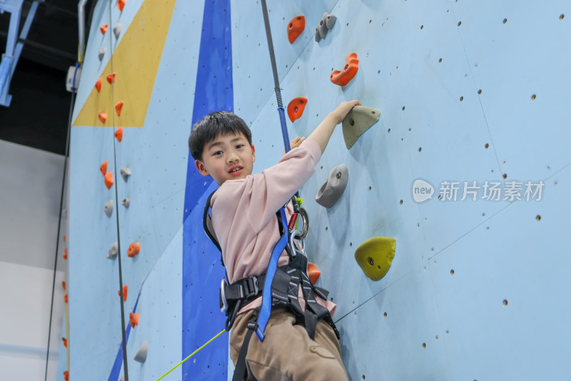 小男孩在室内游乐场练习攀岩