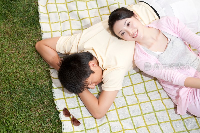 年轻情侣躺在草地上