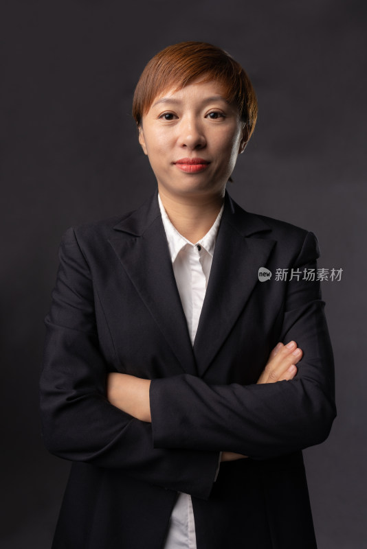 站在黑色背景前穿黑色职业装的中国女性