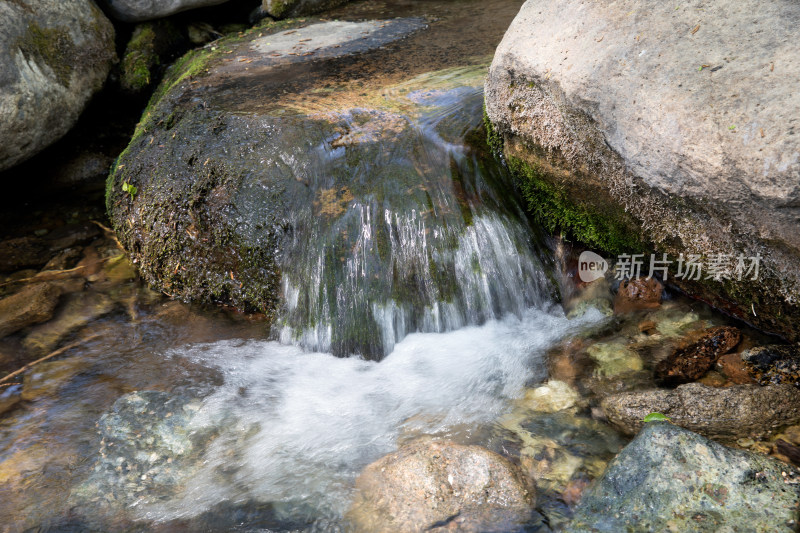 慢门拍摄夏季户外大山里流淌的溪流