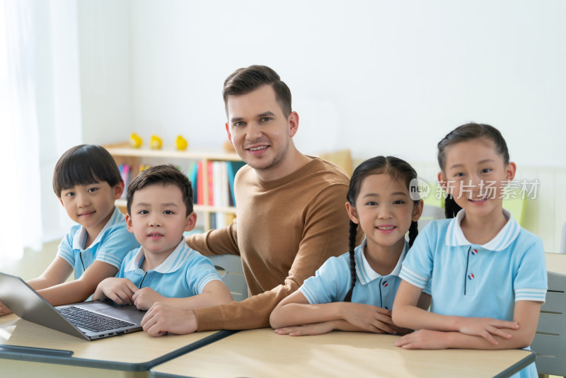 老师在课堂上辅导小学生用电脑