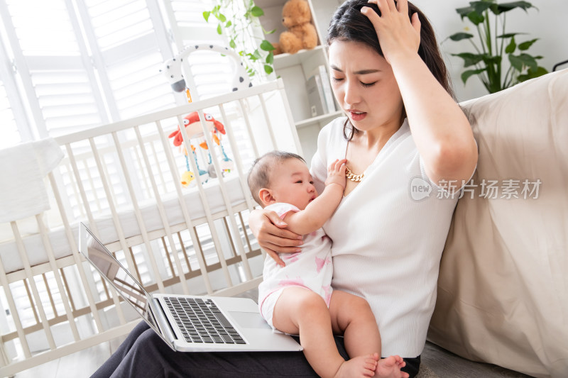 年轻妈妈带着宝宝看电脑