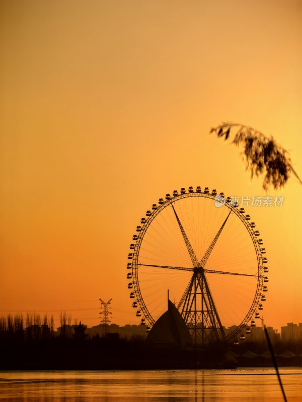 夕阳下的浪漫地标：湖畔摩天轮的金色剪影