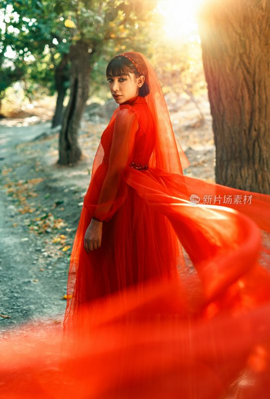 身着红裙女子树林中转身