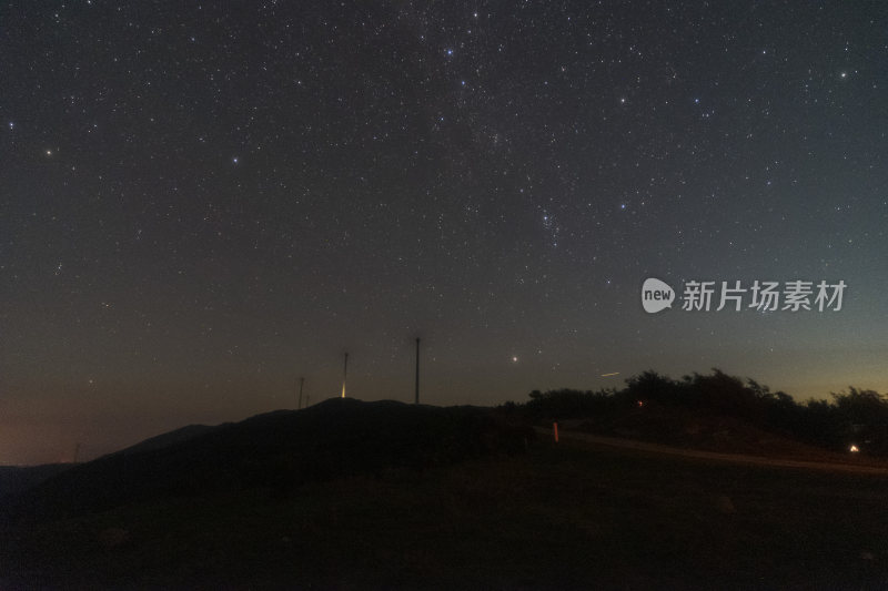 山顶上的星空夜景与风力发电机