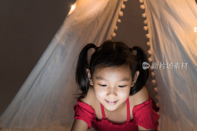 夜晚在白色帐篷里玩耍的中国女孩