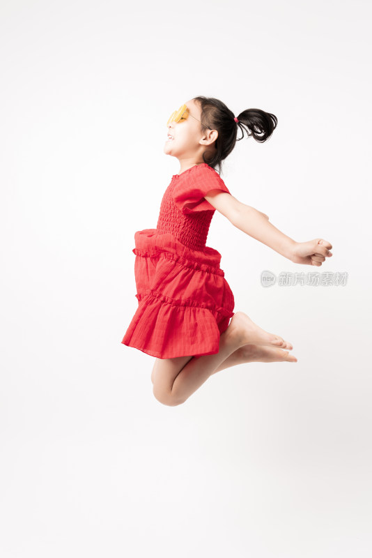 在白色背景前跳跃的中国女孩