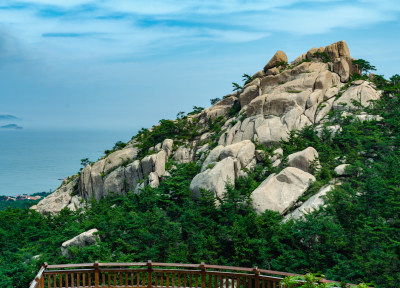 青岛崂山仰口前景栏杆，中景山峰，远处海天