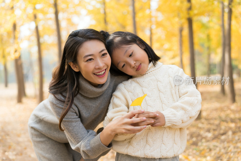 母女二人秋游漫步银杏林