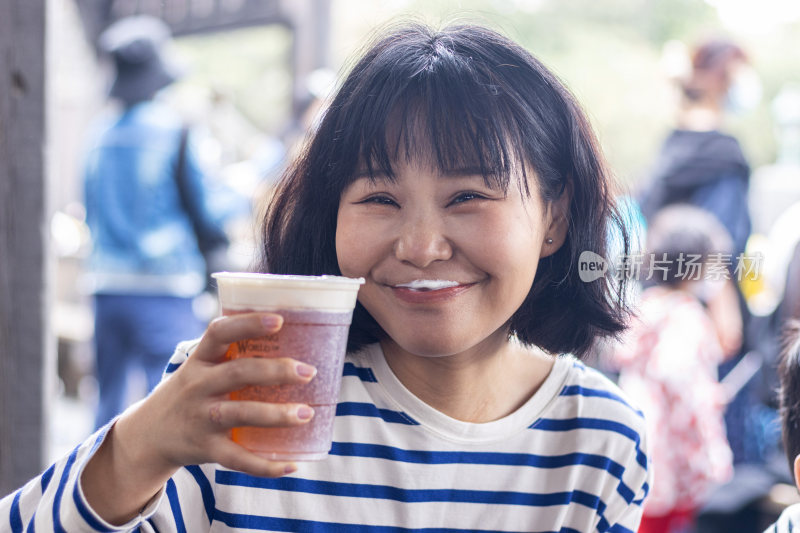 快乐的年轻女人举着一杯啤酒