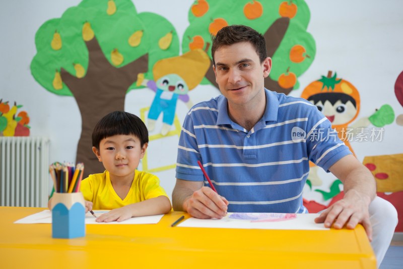 幼儿园外教男老师指导小朋友画画