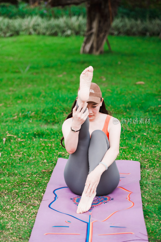 在户外公园里练习瑜伽的亚洲女性