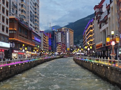 城市河道夜景，两岸霓虹映照湍急水流